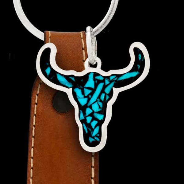 "Our Unforgiven Custom Keychain adds a western touch for any guy or gal. Handcrafted on a German Silver base in the shape of a steer head, it’s filled with our signature crushed turquoise stones.This keychain comes with a genuine leather fob and ring